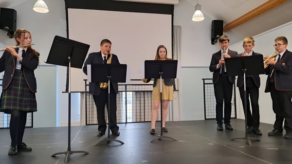 Schüler des Shebbear College stehen in formeller Kleidung auf der Bühne und präsentieren eine Aufführung.