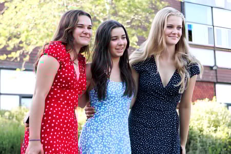 Drei Schülerinnen stehen vor einem Gebäude und Grünflächen auf dem Campus des Shebbear College.