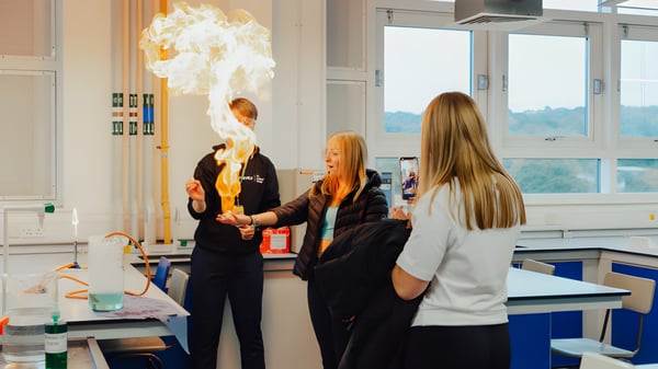 Schüler der The Sheffield College beobachten eine chemische Reaktion mit großer Flamme im Labor.