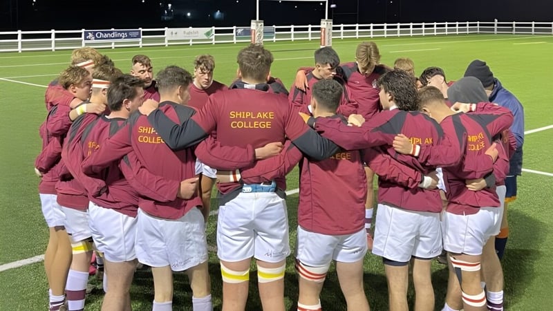 Eine Gruppe von Schülerinnen und Schülern steht zusammen auf dem Sportplatz des Shiplake College.