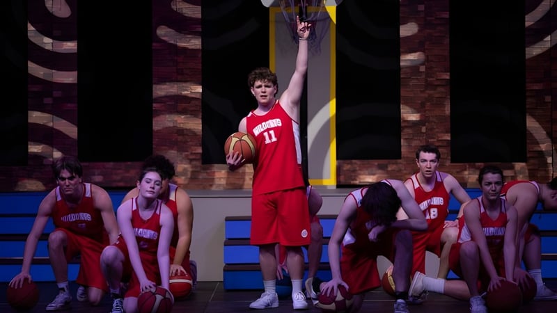 Basketballspieler der Shirley Boys' High School in roten Trikots beim Spiel auf dem Basketballfeld.