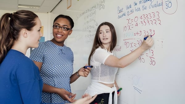Drei Schüler arbeiten gemeinsam an einem Whiteboard bei einer Lernaktivität auf dem Campus der Shrewsbury School.