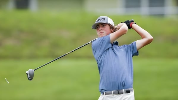 Ein Schüler der Sidcot School schlägt einen Golfball auf einem Rasenfeld.