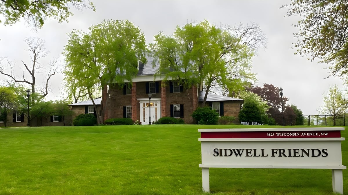 Das Backsteingebäude der Sidwell Friends School steht umgeben von grünen Bäumen und einem gepflegten Rasen.