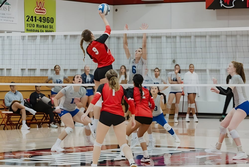 Weibliche Volleyballspielerinnen der Simpson University spielen ein Spiel vor Zuschauern.