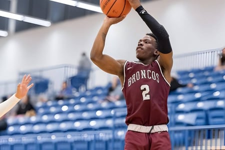 Ein Basketballspieler der Sir Frederick Banting Secondary School springt und wirft den Ball zum Korb auf dem Basketballfeld.