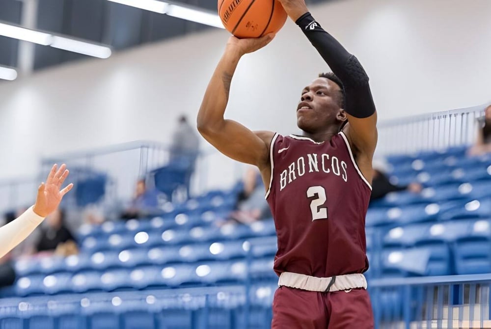 Ein Basketballspieler der Sir Frederick Banting Secondary School springt und wirft den Ball zum Korb auf dem Basketballfeld.
