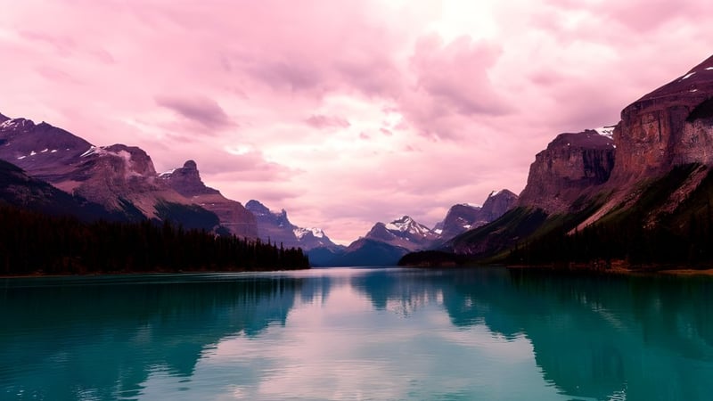 Ein ruhiger See mit türkisfarbenem Wasser vor schneebedeckten Bergen auf dem Gelände der Sir Frederick Banting Secondary School.