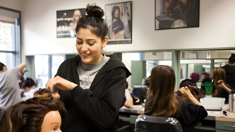 Eine Schülerin der Sir Guy Carleton Secondary School frisiert eine Kundin in einem Friseursalon.