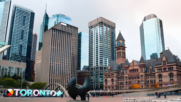 Blick auf die Skyline von Toronto mit dem 'I Love Toronto' Schild vor dem historischen Gebäude auf dem Campus des Sir John A. Macdonald Collegiate Institute.