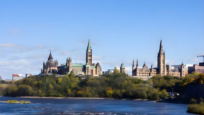 Eine malerische Stadtlandschaft mit Fluss und historischen Gebäuden vor dem Hintergrund eines blauen Himmels.
