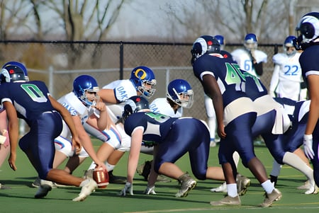 Footballspieler der Sir Wilfred Laurier Secondary School stehen in voller Ausrüstung auf dem grünen Spielfeld.