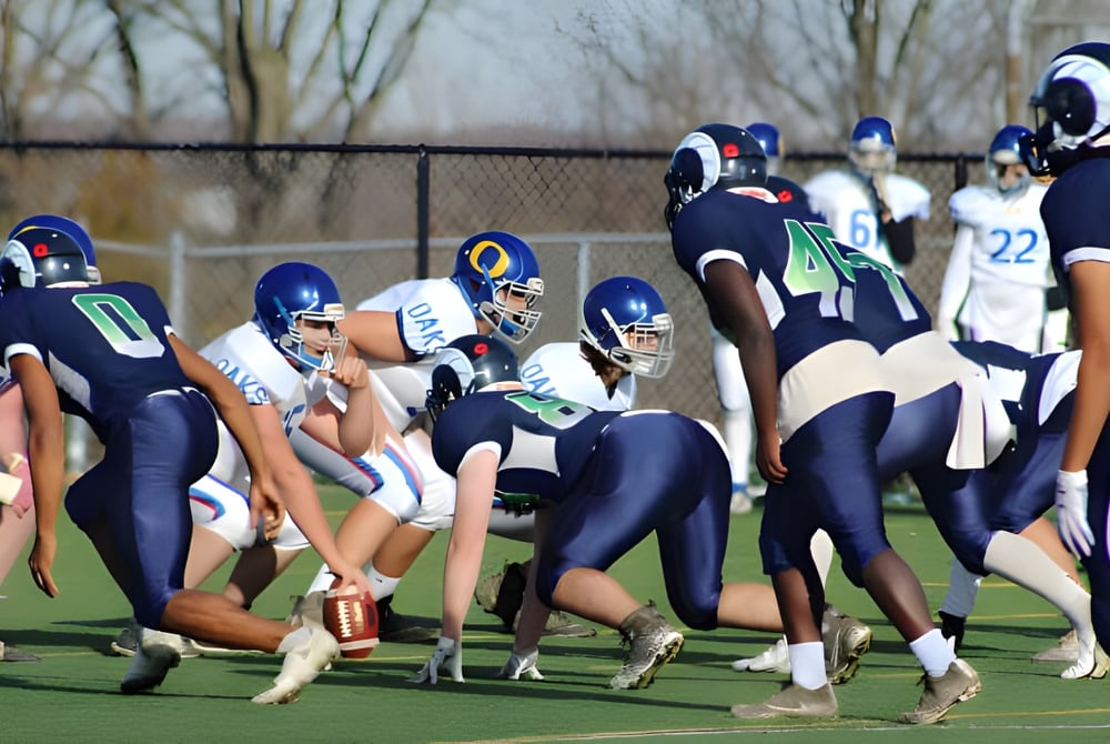 Footballspieler der Sir Wilfred Laurier Secondary School stehen in voller Ausrüstung auf dem grünen Spielfeld.