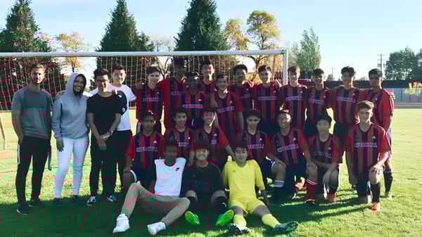 Eine Gruppe von Schülerinnen und Schülern der Sir Winston Churchill Secondary School posiert gemeinsam auf einem Sportplatz.