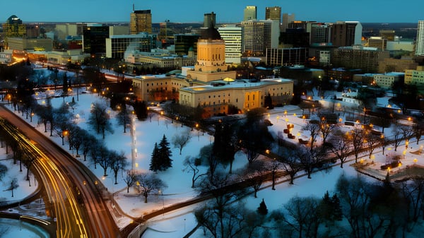 Blick auf eine verschneite Stadt mit einem großen Regierungsgebäude bei Nacht auf dem Campus der Sisler High School.