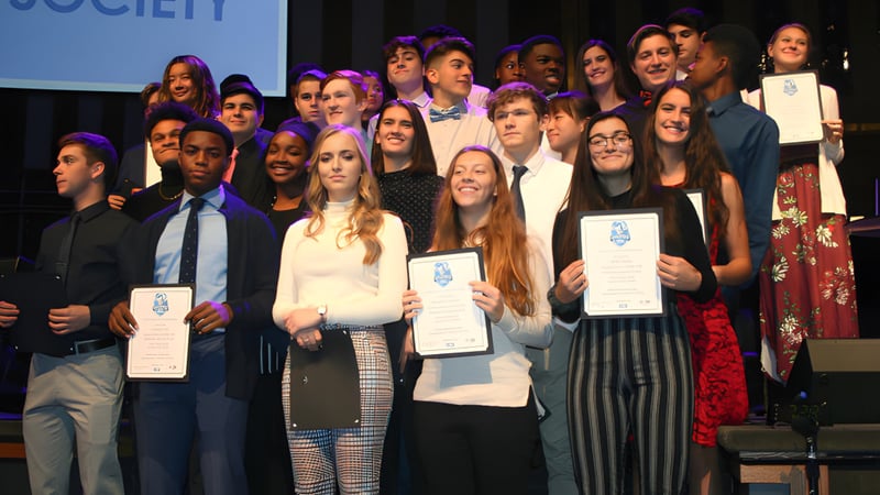 Schüler der Smithtown Christian School erhalten auf der Bühne eine Auszeichnung vor dem Society-Hintergrund.