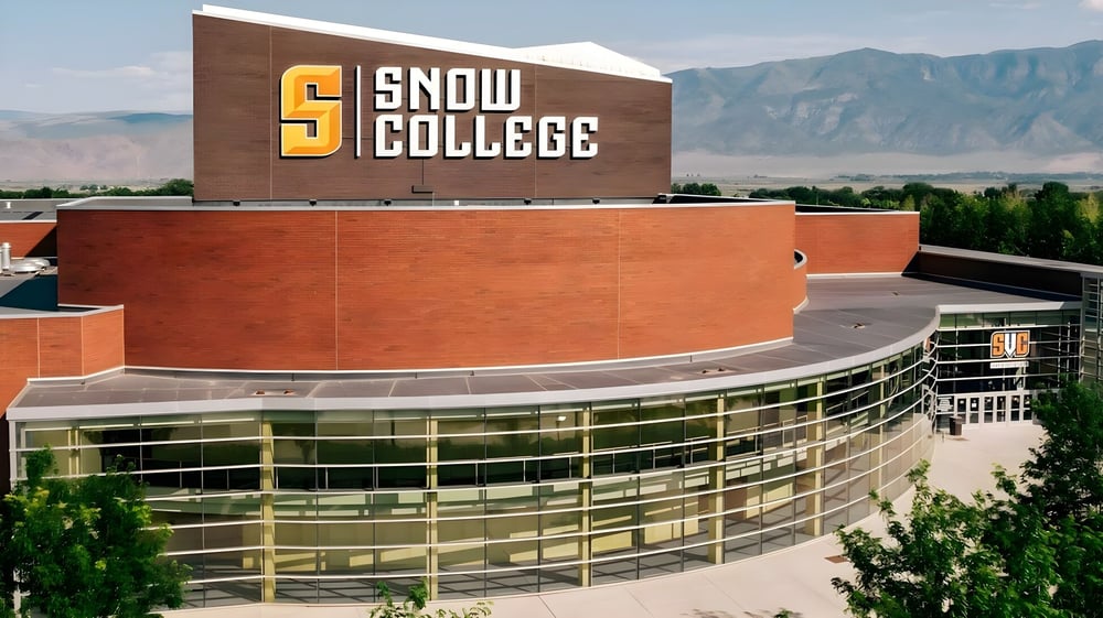 Das moderne Gebäude von Snow College steht vor einer Bergkulisse unter klarem blauem Himmel.