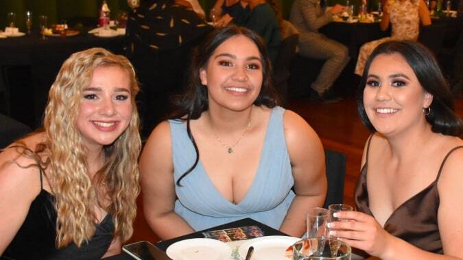 Drei Schülerinnen des Solway College posieren in formeller Kleidung auf einer Veranstaltung.