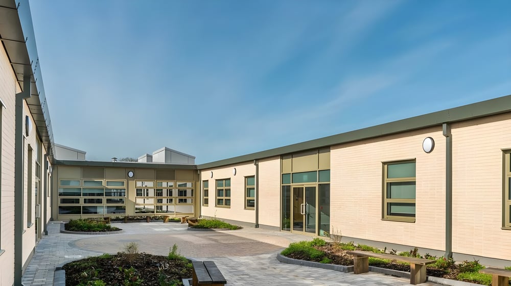 Der Innenhof mit gepflastertem Weg und modernen Backsteingebäuden auf dem Campus der Somerset Studio School.