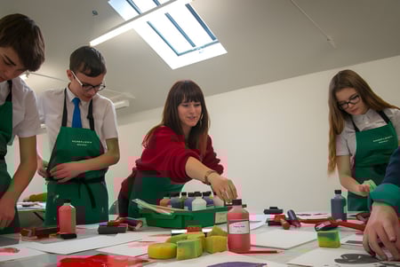 Eine Gruppe Schüler der Somerset Studio School arbeitet im Kunstraum mit verschiedenen Materialien an einer praktischen Aufgabe.