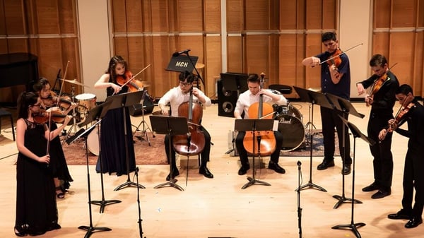 Schüler der Somervale School spielen verschiedene Instrumente während eines Konzerts in einem Holzkonzertsaal.