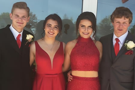 Vier Schüler der Souris Regional School stehen in festlicher Kleidung zusammen bei einem besonderen Schulereignis.