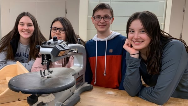 Vier Schülerinnen und Schüler der Souris Regional School nehmen in einem Studio eine Aufnahme mit einem Mikrofon auf.