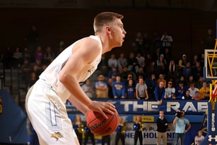 Ein Basketballspieler der South Carleton High School steht auf dem Basketballfeld mit Zuschauern im Hintergrund.