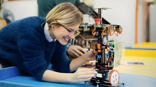 Eine Schülerin der South Carleton High School konzentriert sich auf die Reparatur eines mechanischen Geräts in der Werkstatt.