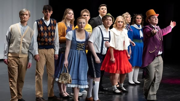 Eine Gruppe von Schülerinnen und Schülern steht in bunten Outfits auf einer Bühne der South Christian High School.