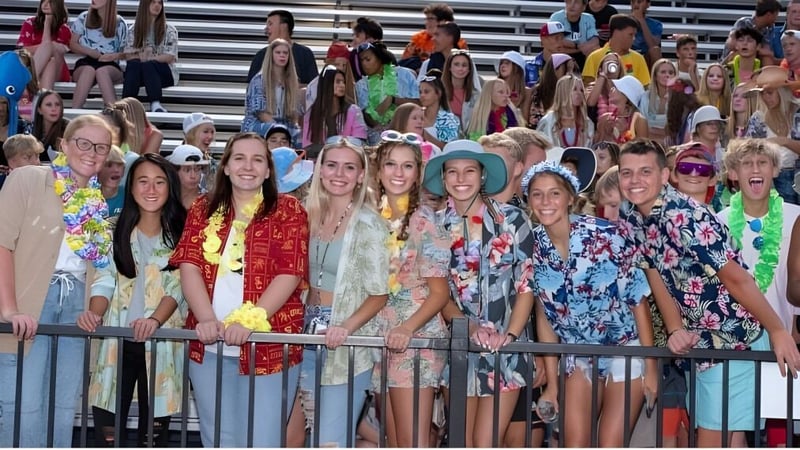 Eine Gruppe Schülerinnen der South Christian High School posiert zusammen vor einem Gebäude hinter einem Metallgeländer.
