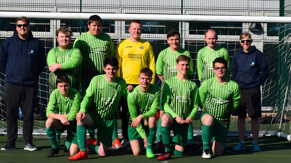 Eine Gruppe von Fußballspielerinnen und Fußballspielern des South Downs College posiert gemeinsam auf dem Fußballfeld.