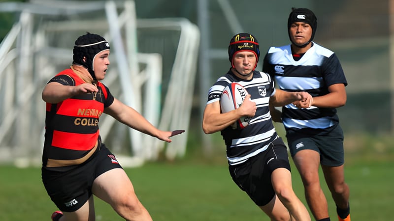 Drei Rugbyspieler in Aktion auf dem Sportfeld der South England International School Brighton.
