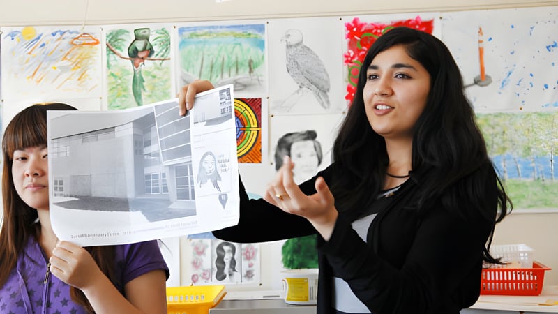 Zwei Schülerinnen zeigen und besprechen ein Kunstwerk während des Kunstunterrichts am South Hill Education Centre.