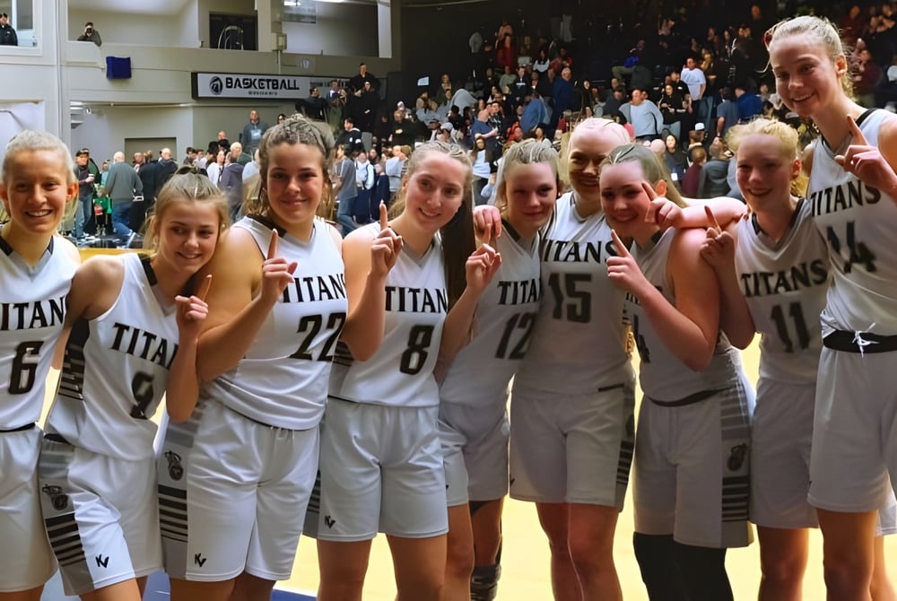 Eine Gruppe junger Basketballspielerinnen der South Kamloops Secondary School steht gemeinsam in der Sporthalle.