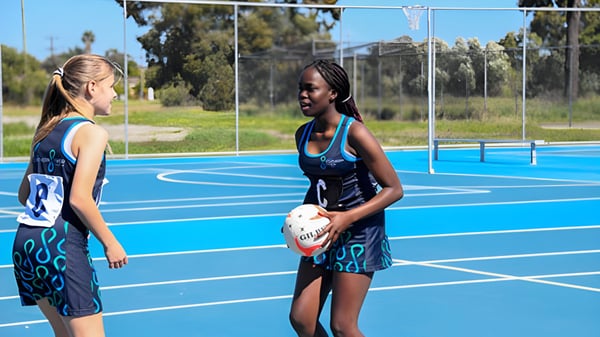 Zwei Schülerinnen in Sportkleidung stehen auf dem Basketballplatz im Freien beim Southern River College.