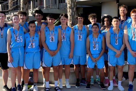 Eine Gruppe Jugendlicher im blauen Basketball-Uniform steht vor dem Gebäude der Southport State High School.