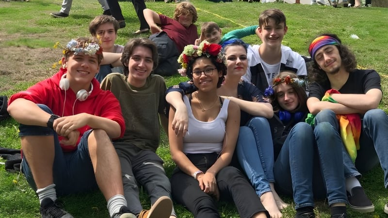 Eine Gruppe Schüler sitzt gemeinsam auf dem Gras in einem Außenbereich der Sparhawk School.