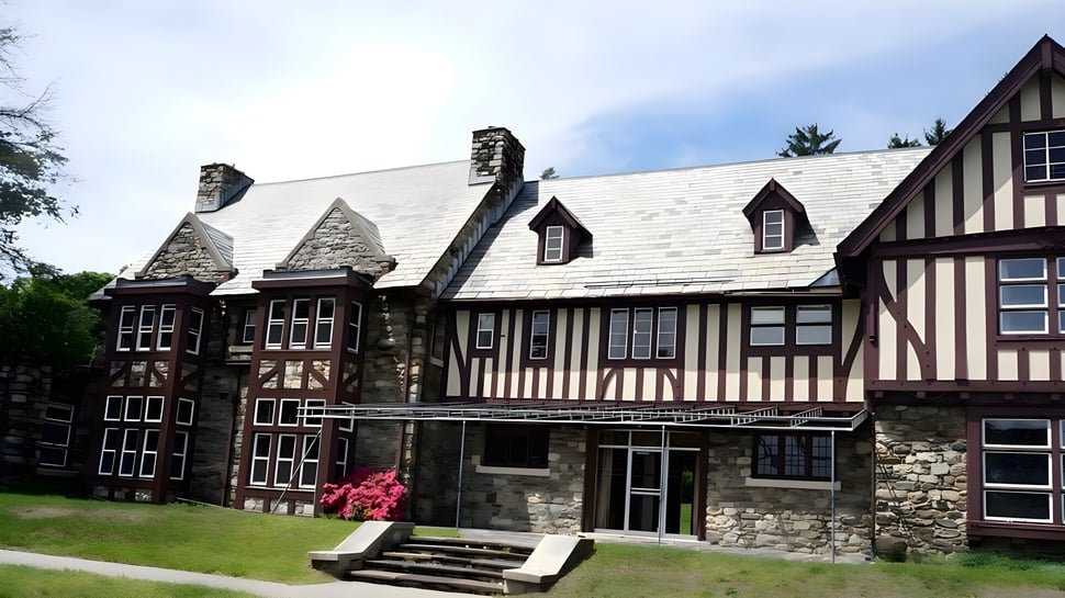 Das Tudor-Gebäude der Sparhawk School steht umgeben von einer grünen Landschaft.