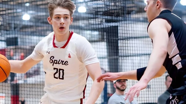 Zwei Schüler der SPIRE Academy spielen Basketball auf einem Außenplatz mit Stadtpanorama im Hintergrund.