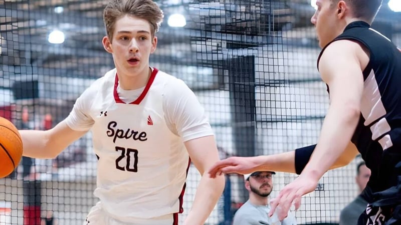 Zwei Schüler der SPIRE Academy spielen Basketball auf einem Außenplatz mit Stadtpanorama im Hintergrund.