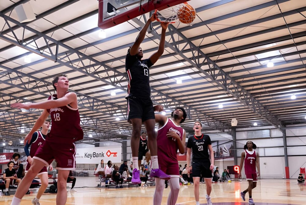 Zwei Schüler der SPIRE Academy kämpfen auf dem Basketballfeld um den Ball vor Zuschauern.