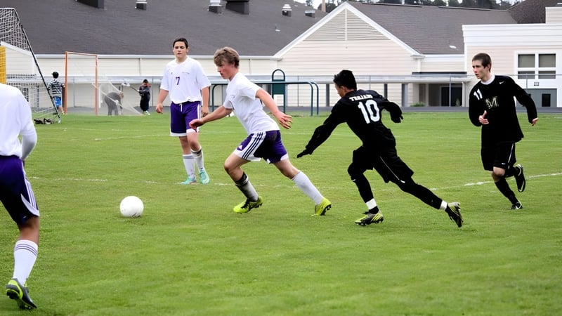 Schüler der Spring Street International School spielen ein Fußballspiel auf dem Sportplatz vor einem Schulgebäude.