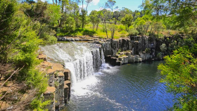 Eine malerische Landschaft mit Wasserfall und Wald im Umfeld der Springbank School.