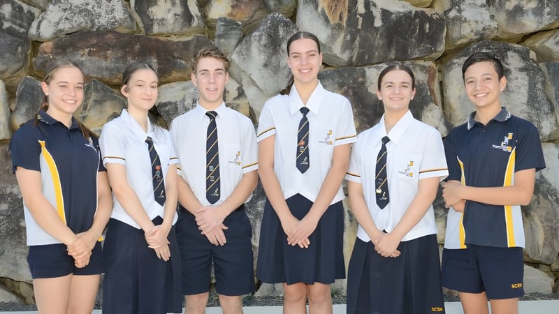 Sechs Schüler der Springfield Central State High School stehen vor einem felsigen Bergpanorama.