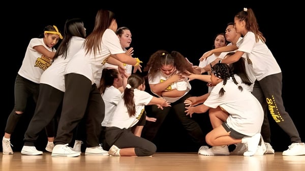 Eine Gruppe von Tänzern führt auf der Bühne eine dynamische Tanzaufführung auf dem Campus der Springfield Central State High School auf.
