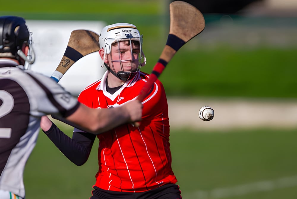 Ein Schüler der St. Aidan's Comprehensive School spielt Fußball auf einem Rasenfeld, während ein weiterer Spieler in der Nähe ist.