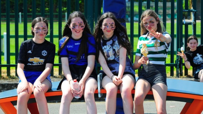 Eine Gruppe Schülerinnen sitzt gemeinsam auf einem bunten Spielplatz auf dem Campus der St Ailbe's School.