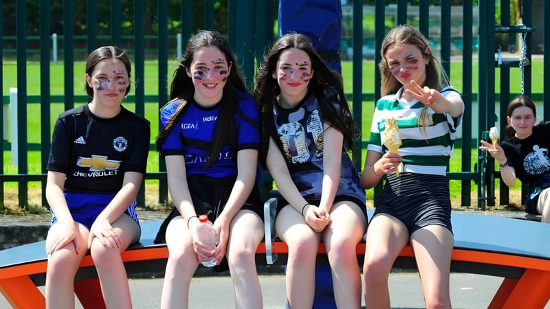 Eine Gruppe von Schülerinnen sitzt gemeinsam auf einem bunten Spielplatz auf dem Gelände der St Ailbe's School.