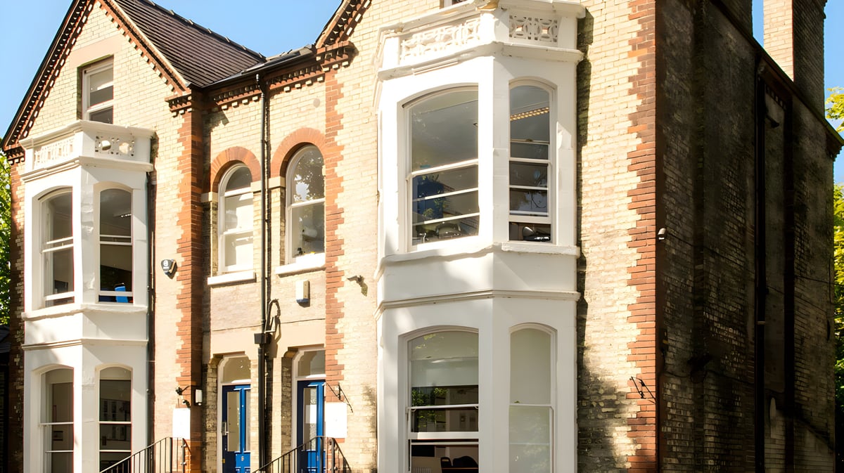 Das mehrstöckige Backsteingebäude mit verzierten Fenstern steht am Campus des St. Andrew’s College in Cambridge.